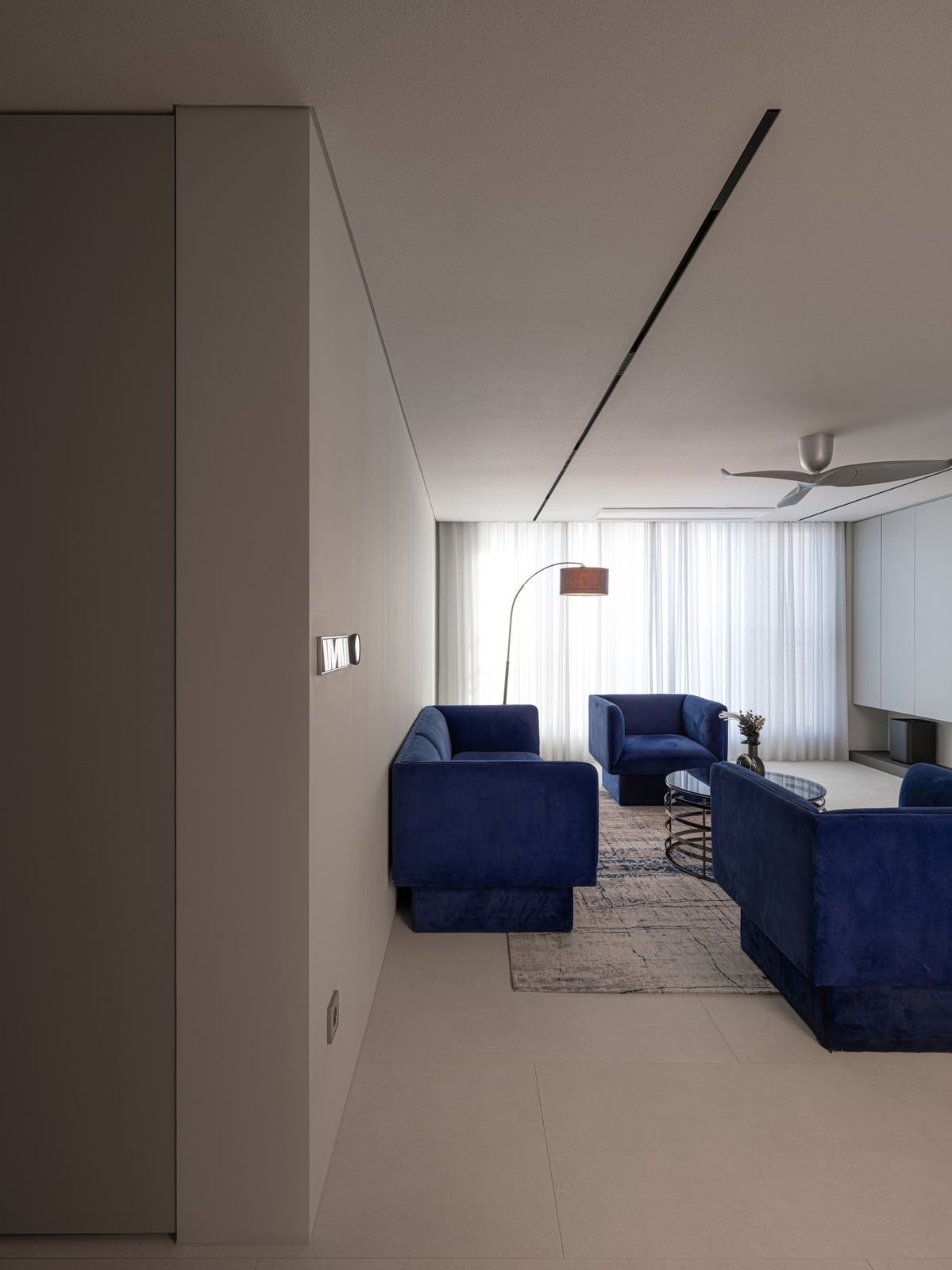 Style reference: a living room with navy velvet sofas and sheer curtains