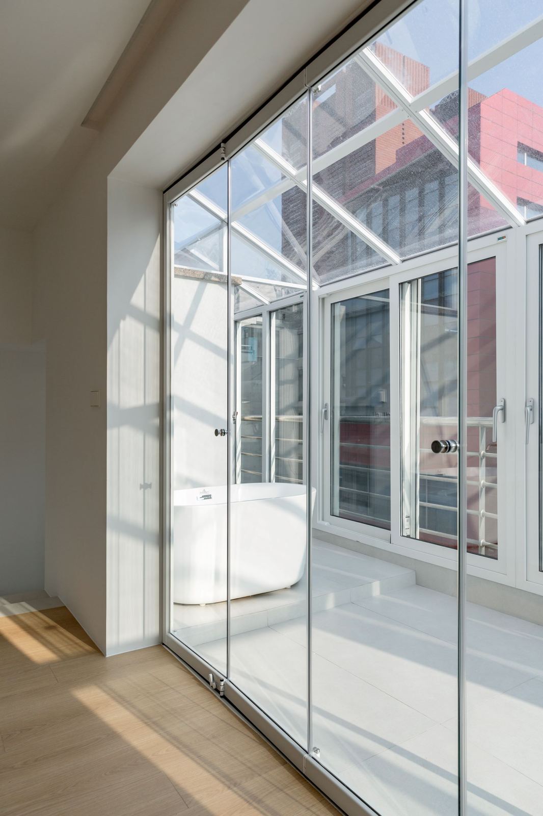 Style reference: a glass sunroom extension with a freestanding bathtub visible beyond